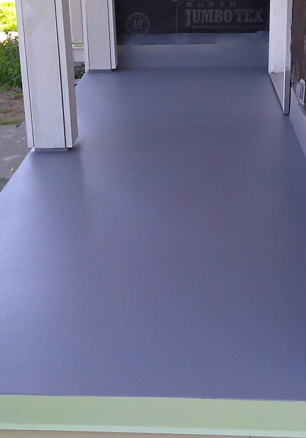 A freshly painted gray porch with square columns and unfinished exterior wall sections, ideal for deck and patio waterproofing in Auburn WA.